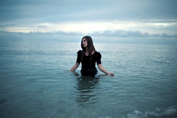 Ragazza in piedi in acqua fino alla vita vestita