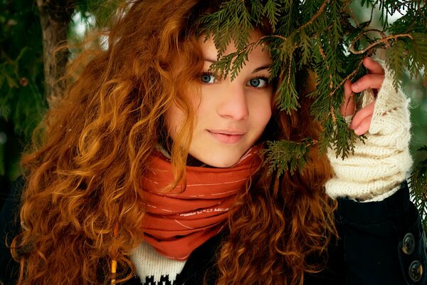 Beautiful look. Red-haired girl posing in the woods in winter