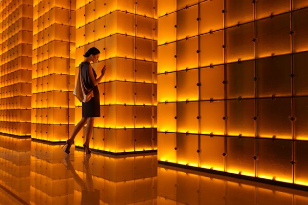 Ragazza in piedi sullo sfondo di un muro di piccole piazze