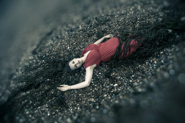 Séance photo au milieu de la mer. fille en robe rouge