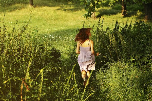 Una ragazza che corre in un campo verde e soleggiato