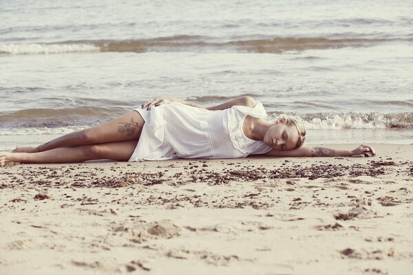 The girl is lying on the seashore