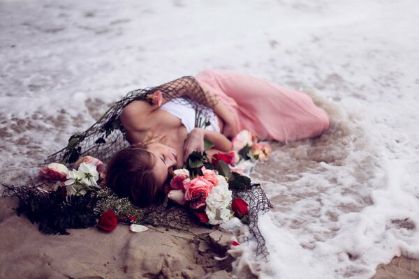 Fille se trouve dans la mousse de mer avec des fleurs