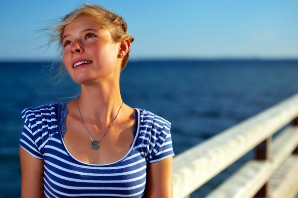 A dreaming girl in a T-shirt by the sea