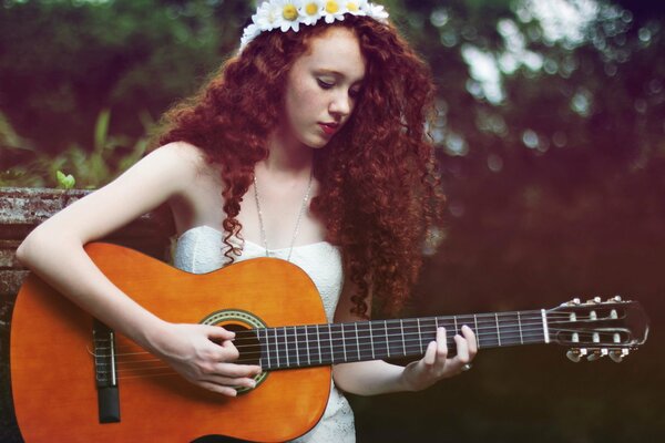 A red-haired girl plays the guitar