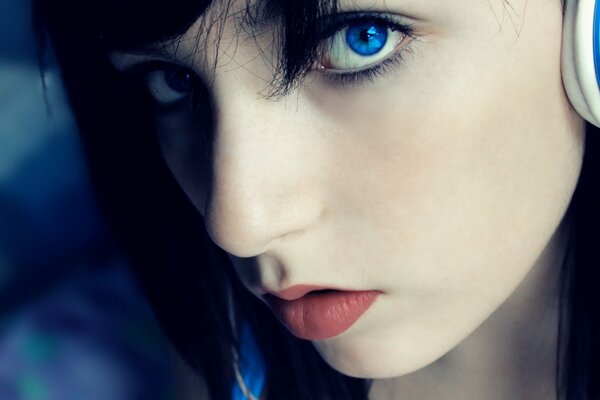 Blue eyes of a girl with headphones