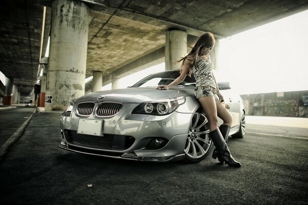 A red-haired Asian woman on the background of a bmw