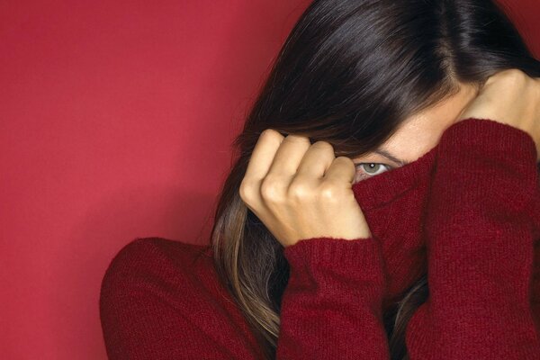 The brunette peeks out from behind the high neck of the sweater