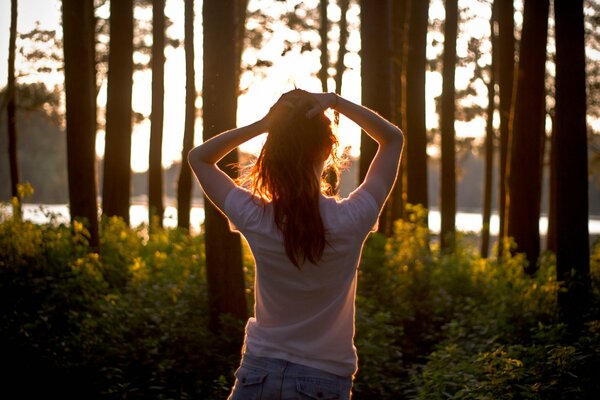 Fille au coucher du soleil dans la forêt