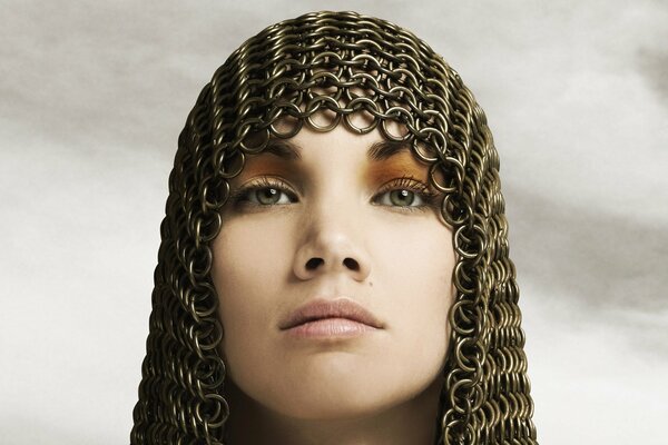 The face of a girl with a chain mail on her head