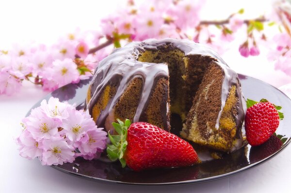 Schokoladenkuchen mit Erdbeeren und einem Zweig rosa Jasmin