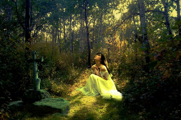 A girl in the forest near the cross