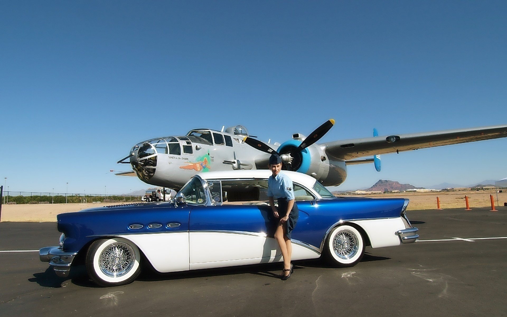 avión coche técnica coche chica muff falda medias rareza cielo montaña aeródromo zapatos piernas