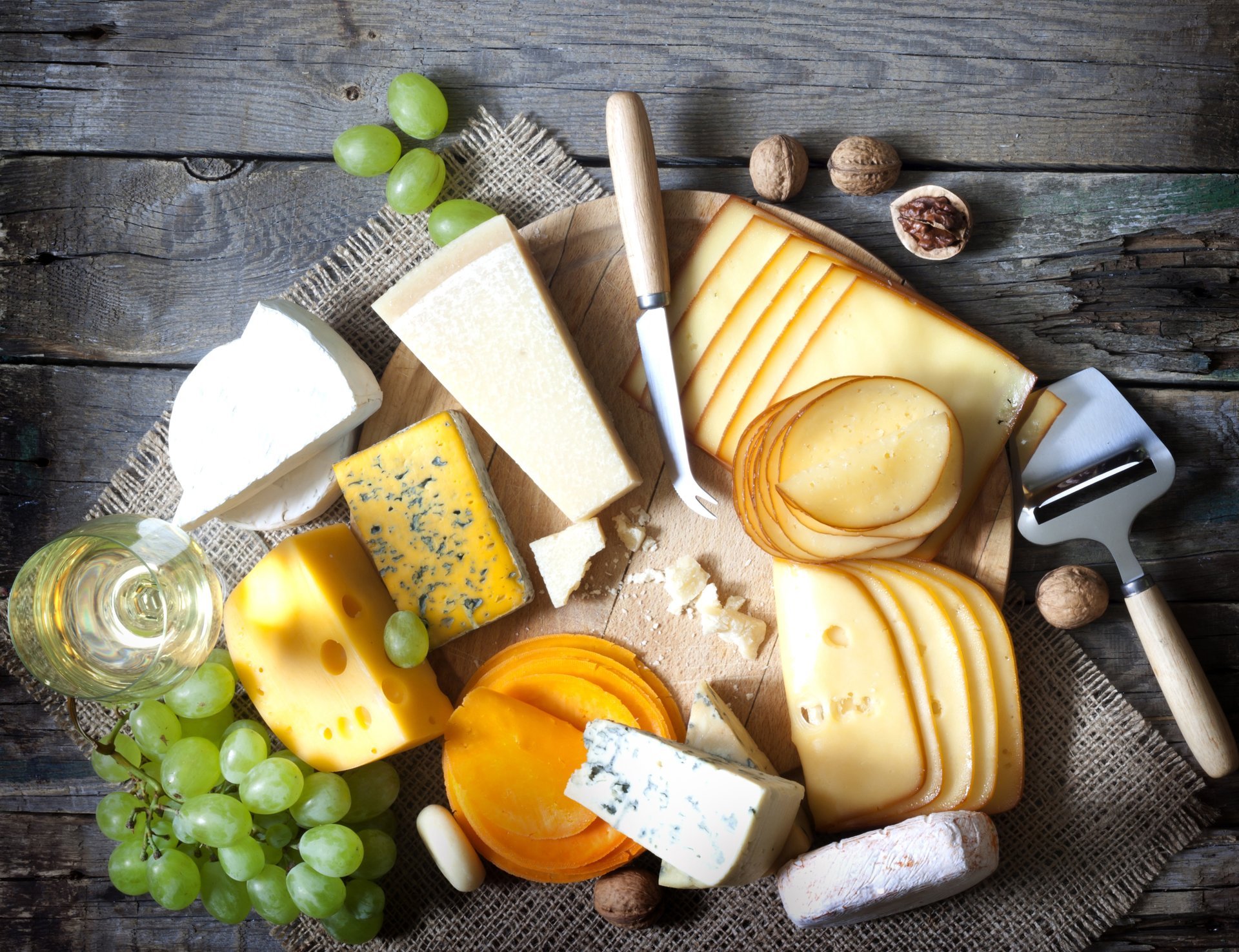 table cheese grapes glass wine white walnuts slice