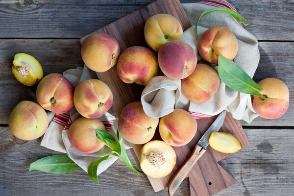 Ripe peaches on a towel are waiting to be cut