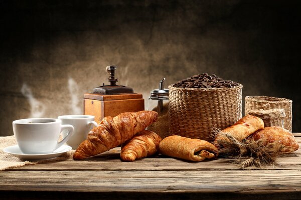 Frisches Brot zum Tisch mit einer Tasse Kaffee in einer Kaffeemühle
