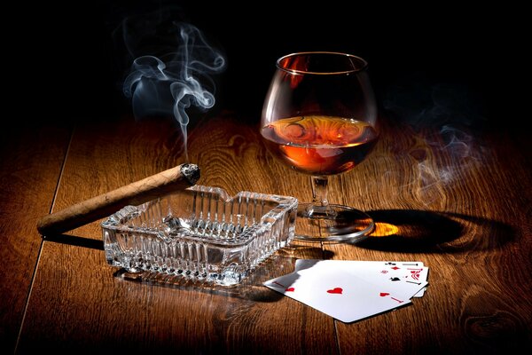 Carte sigaro e cognac in un bicchiere