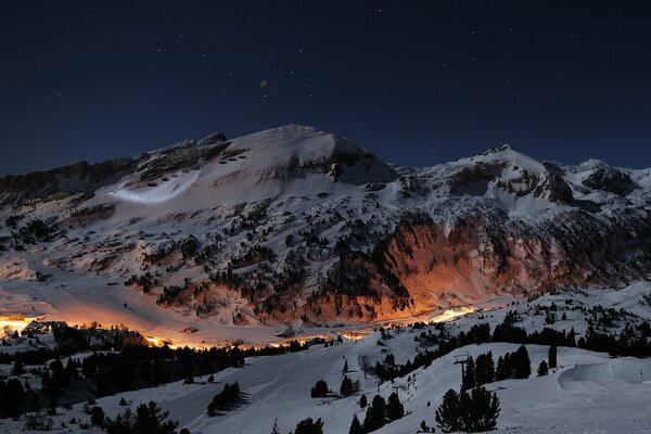 Route de montagne de nuit éclairée par la lumière orange des lanternes