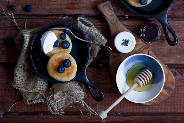 Buñuelos servidos con arándanos y crema agria