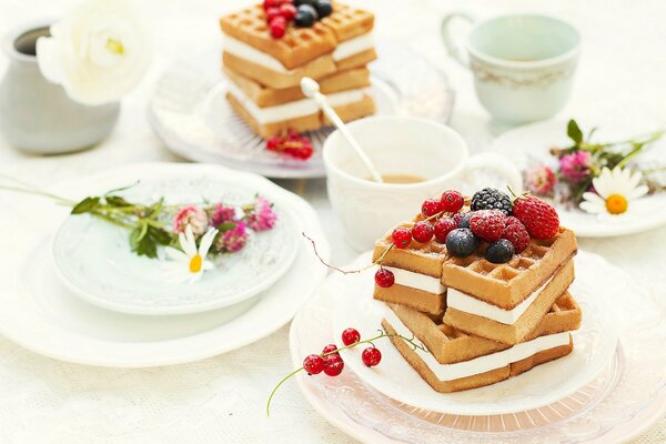 Frühstück-Stillleben, Waffeln mit Sahne und Beeren und Kamillentee