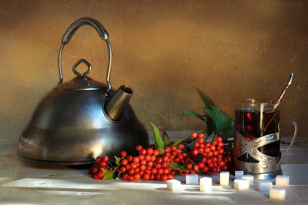 Théière et tasse de thé sur la table. Baies rouges au thé