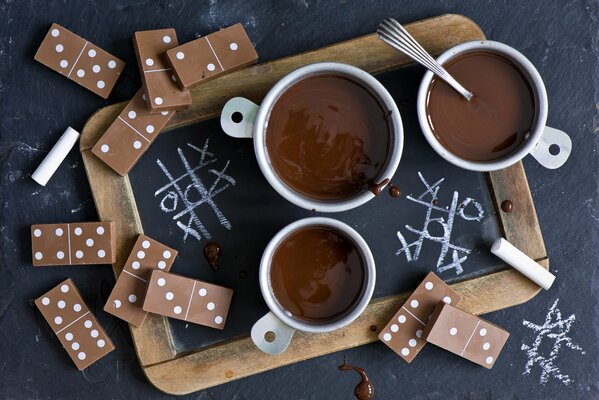 Chocolate caliente y dominó en la mesa