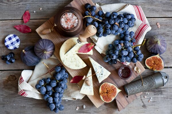 Nature morte sur un tableau noir avec des baies et du fromage