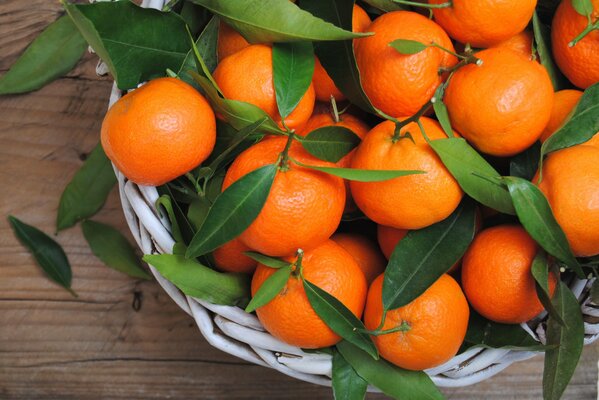 Oranges récoltées avec des feuilles sur une plaque sur la table