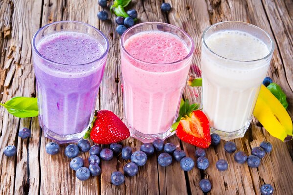 Trois verres avec milkshake et baies sur la table