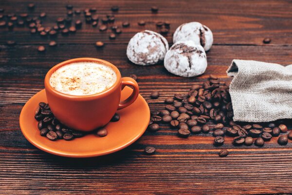 Morning coffee on the background of scattered grains on the table from a bag. k