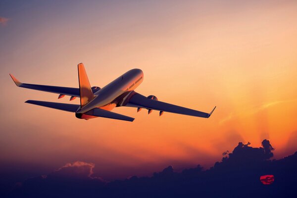 Avión despega en medio de la puesta del sol