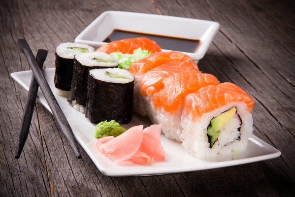 Sushi on a white platter with chopsticks