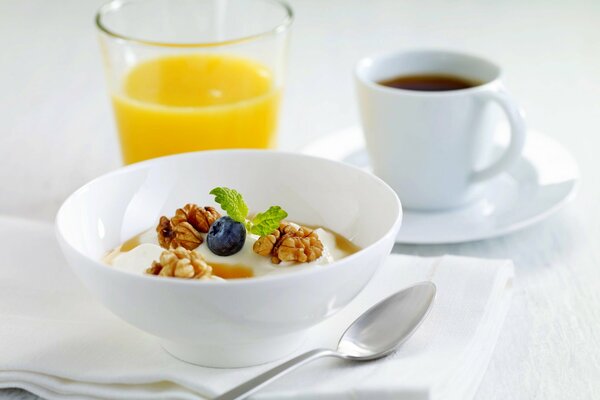 Frühstück mit Saft, Kaffee und Müsli mit Nüssen