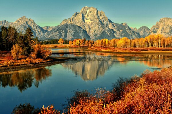 Paesaggio autunnale con fiume e montagne