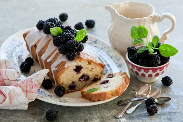 Beerenkuchen mit Brombeeren auf einem Teller mit Minze garniert