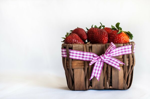 Basket with yagodomi krubniki and a pink bow