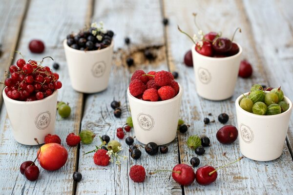 Fünf Gläser mit Beeren stehen auf dem Tisch