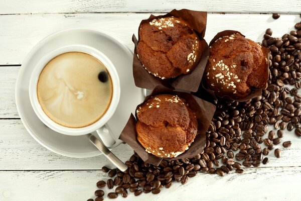 Eine Tasse duftenden Kaffee mit Cupcake zum Frühstück