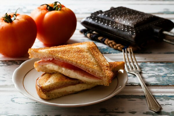 Delicioso sándwich de queso, jamón y tomate