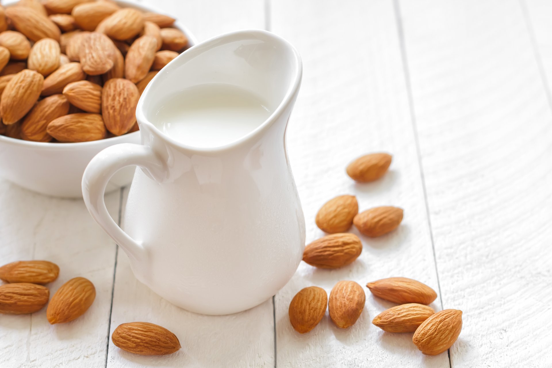 milch krug mandeln nüsse teller tisch