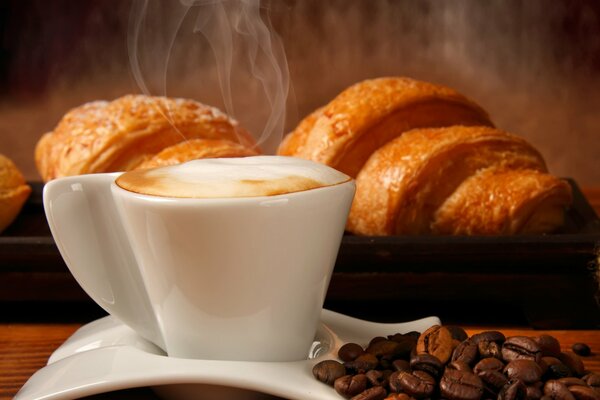 Heißer Kaffee mit Croissants und Kaffeebohnen