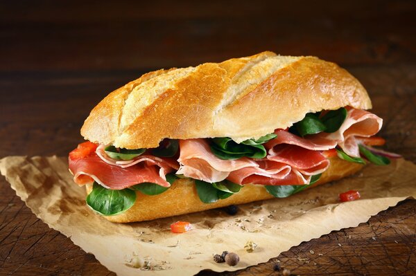 Juicy sandwich of a loaf of ham and greens