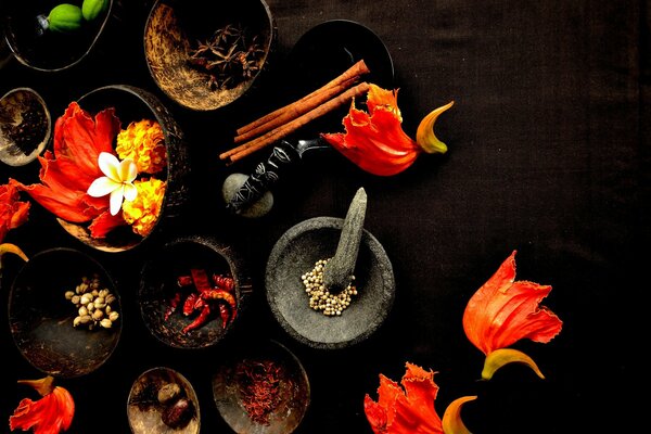 Flower petals and spices in bowls on the table