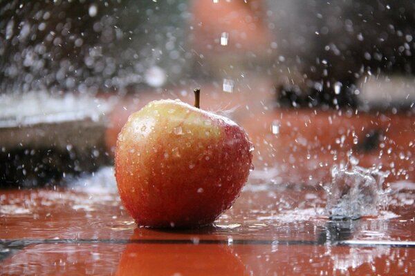 Salpicaduras de agua caen sobre la manzana