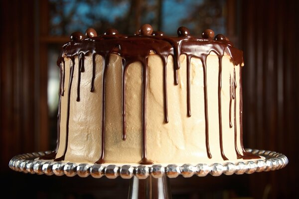 Torta bianca glassata al cioccolato su un supporto