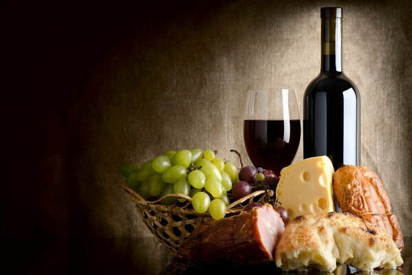 Композиция из вина, сыра, балыка, хлеба и винограда в корзинке