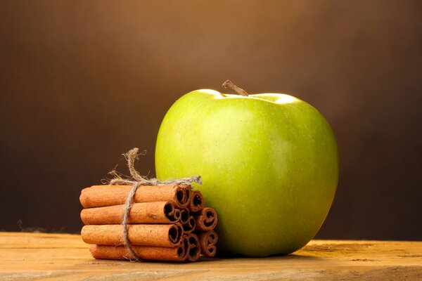 Image grand écran d une pomme avec des bâtons de cannelle