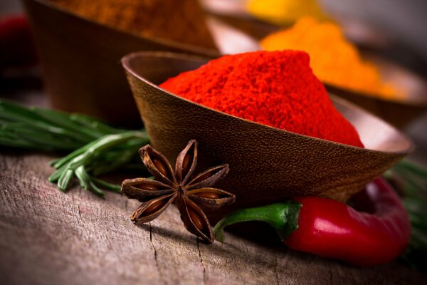 Especias en una taza de madera cardamomo y pimiento rojo