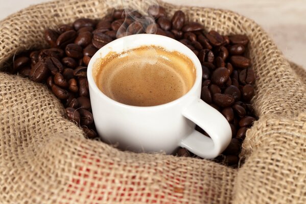 A cup of coffee in a bag with coffee beans