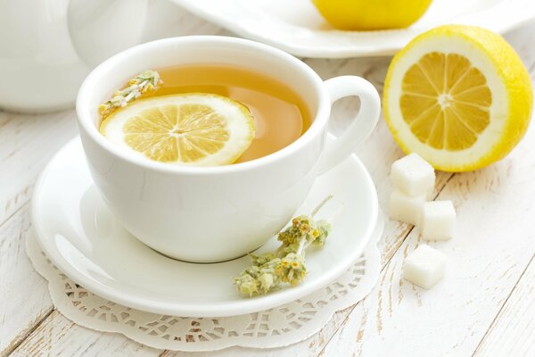 Té aromático con limón y azúcar en una taza blanca